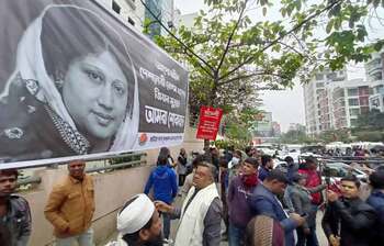 Leaders and activists holding pictures and black flags at Evercare