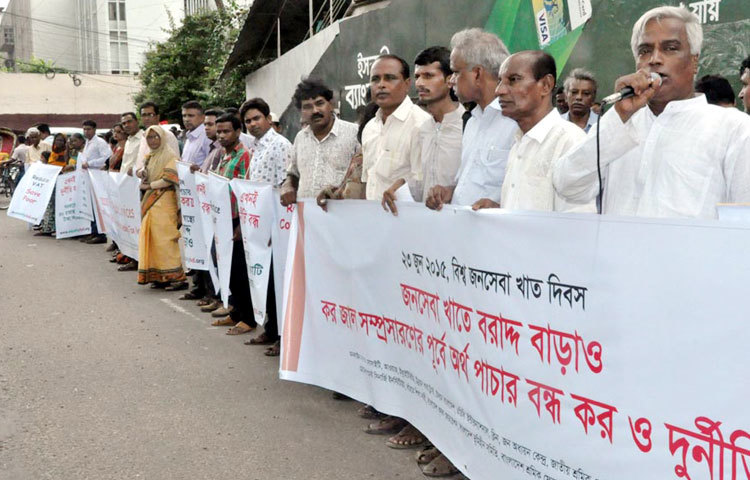 জাতীয় প্রেসক্লাবের সামনে রোববার কৃষক-শ্রমিক ও নাগরিক সমাজভিত্তিক ২৯টি সংগঠন আয়োজিত এক মানববন্ধন থেকে জনসেবা খাতে বরাদ্দ বাড়ানোর দাবি