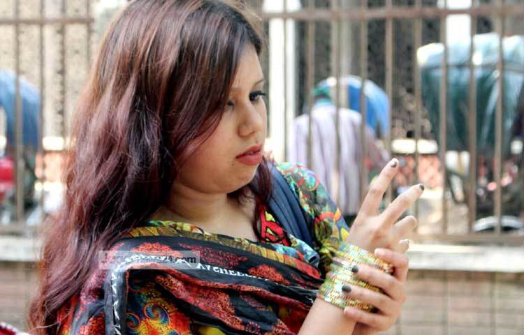 চুড়ি মানানসই হয়েছে কী না তা পরীক্ষা করে নিতে ব্যস্ত সৌন্দর্য সচেতন এই তরুণী। ছবি : বিপ্লব দিক্ষিৎ।