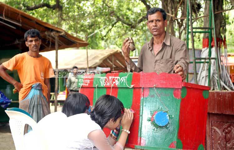 কালের বিবর্তনে হারিয়ে যাচ্ছে গ্রাম বাংলার ঐতিহ্য বায়োস্কোপ। তবে বিভিন্ন মেলা উপলক্ষে মাঝে মধ্যে বায়োস্কোপওয়ালাদের দেখা মেলে। ছবি : বিপ্লব দিক্ষিৎ।
