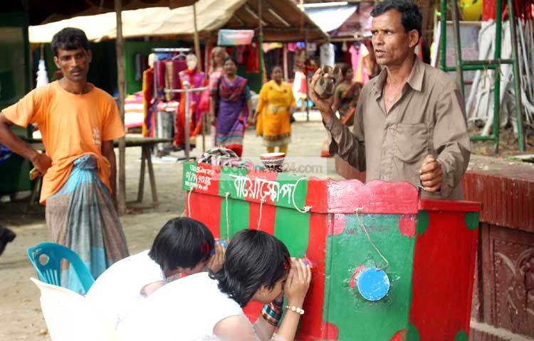 বায়োস্কোপ দেখায় মগ্ন শিশুরা। ছবি : বিপ্লব দিক্ষিৎ।