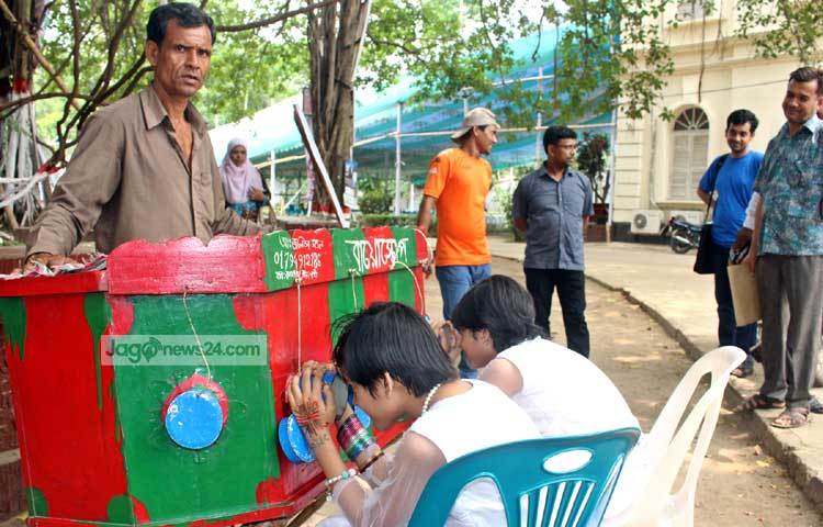 বয়স্করা দূর থেকে শিশুদের বায়োস্কোপ দেখার দৃশ্য দেখে শৈশবের স্মৃতিচারণ করছেন। ছবি : বিপ্লব দিক্ষিৎ।