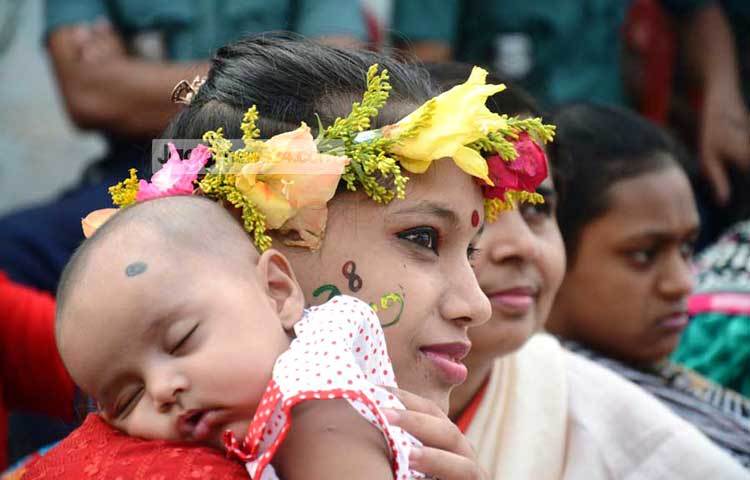 এক মা তার কোলের শিশু নিয়ে শামিল হয়েছেন বৈশাখী উৎসবে। ছবি : বিপ্লব দিক্ষিৎ।