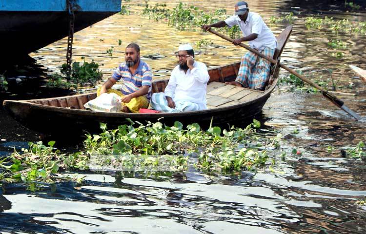 নদীর মঝে নোঙর করে থাকা লঞ্চে নৌকাযোগে যাত্রীদের পৌঁছে দিয়ে আসছেন মাঝিরা। আলোকচিত্রী : বিপ্লব দিক্ষিৎ।