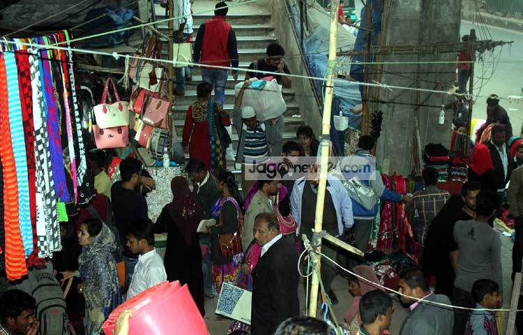 নিউমার্কেট এলাকায় ফুটওভার ব্রিজে ওঠার সিঁড়ির মুখে জুতার দোকানে ক্রেতাদের ভিড় লেগেই থাকে। ফলে ফুটওভার ব্রিজ ব্যবহারকারীদের অনেক কষ্টে পার হতে হয়। প্রশাসন যেনো দেখেও দেখছে না। ছবি : বিপ্লব দিক্ষিৎ