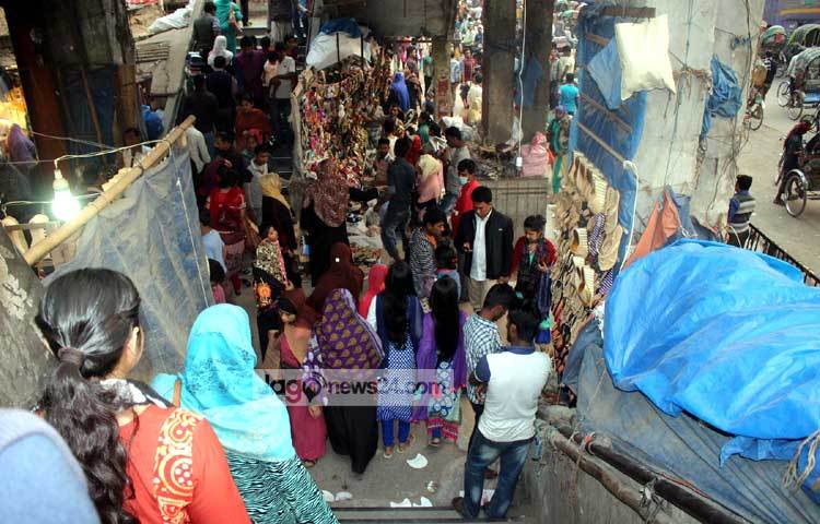 নিউমার্কেট এলাকায় ফুটওভার ব্রিজে ওঠার সিঁড়ির মুখে জুতার দোকানে ক্রেতাদের ভিড় লেগেই থাকে। ফলে ফুটওভার ব্রিজ ব্যবহারকারীদের অনেক কষ্টে পার হতে হয়। প্রশাসন যেনো দেখেও দেখছে না। ছবি : বিপ্লব দিক্ষিৎ