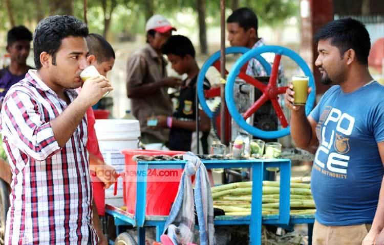 গরমে ক্লান্তি দূর করতে অনেকেই পান করছেন আখের রস ও ঠাণ্ডা পানি। ছবি : রবিউল এহ্সান রিপন।
