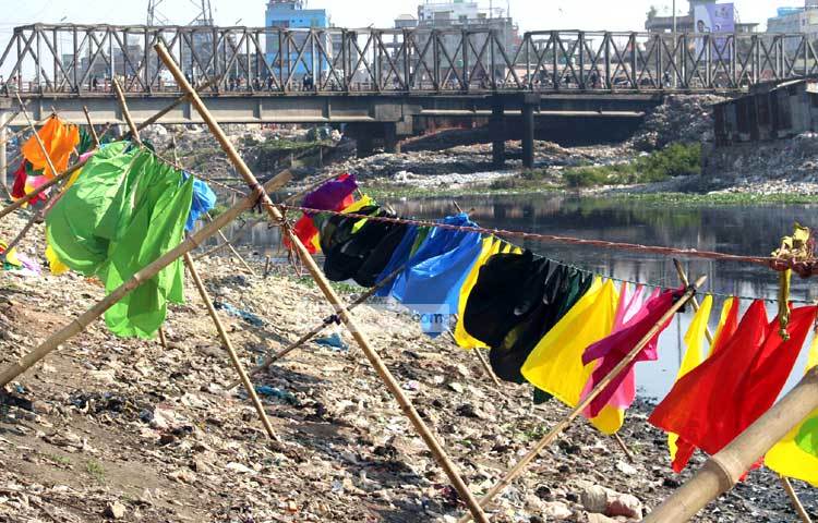 বুড়িগঙ্গার দূষিত পানিতে এসব কাপড় ধুয়ে রোদে শুকাতে দেওয়া হয়েছে। আজ দুপুরে এদৃশ্য ক্যামেরাবন্দি করেছেন আলোকচিত্রী বিপ্লব দিক্ষিৎ।