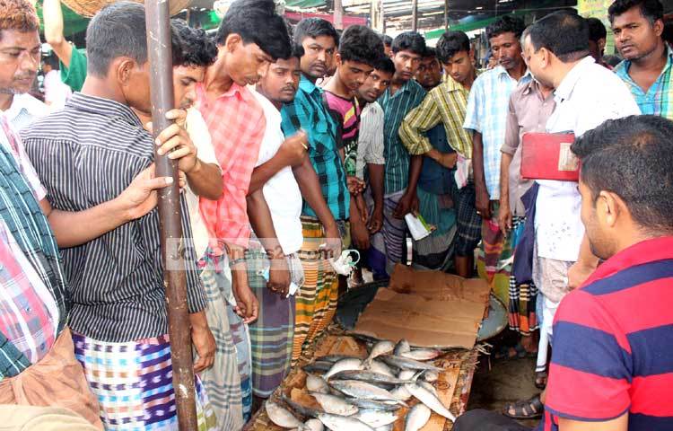 ইলিশ মাছের বিক্রেতাকে নিয়ে ক্রেতাদের জটলা। ছবি : বিপ্লব দিক্ষিৎ।