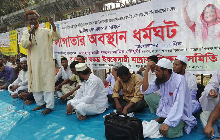 জাতীয় স্কেলে বেতনের দাবিতে স্বতন্ত্র ইবতেদায়ী মাদরাসা শিক্ষকদের লাগাতার অবস্থান ধর্মঘট ১৯তম দিনের মত অব্যাহত রয়েছে।