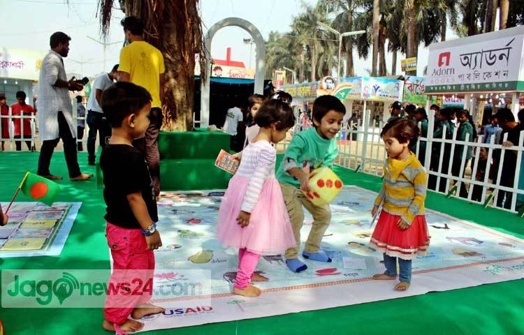 বইমেলায় আপন মনে খেলছে শিশুরা। ছবি : বিপ্লব দিক্ষিৎ