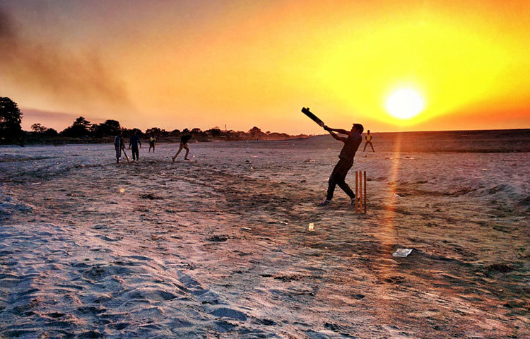 সূর্যোদয় উৎসবের সঙ্গে চলছে ক্রিকেট খেলা। বালুর মাঠের মধ্যে চলছে এই ক্রিকেট আয়োজন। ছবি : ইএসপিএন