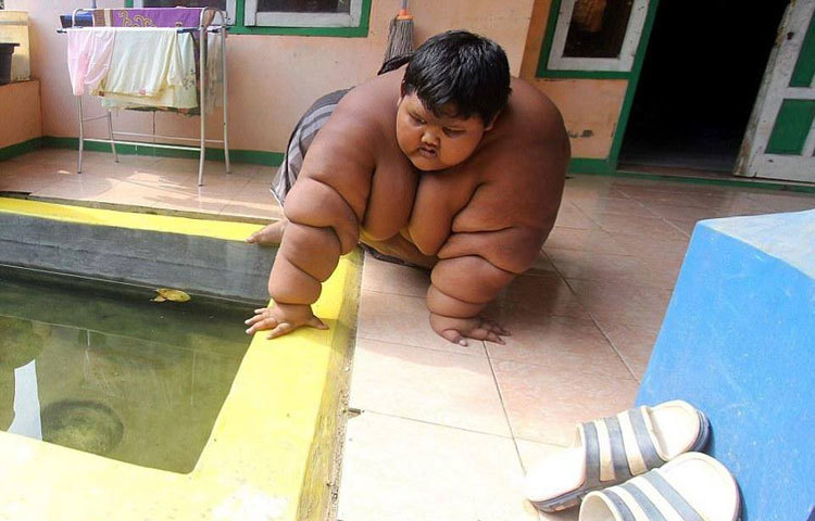 শরীরের ওজন বেশি হওয়ার কারণে আর্য স্কুলে যেতে পারছে না। ছবিতে হামাগুড়ি দিয়ে চৌবাচ্চার মধ্যে গোসল করতে যাচ্ছে আর্য।