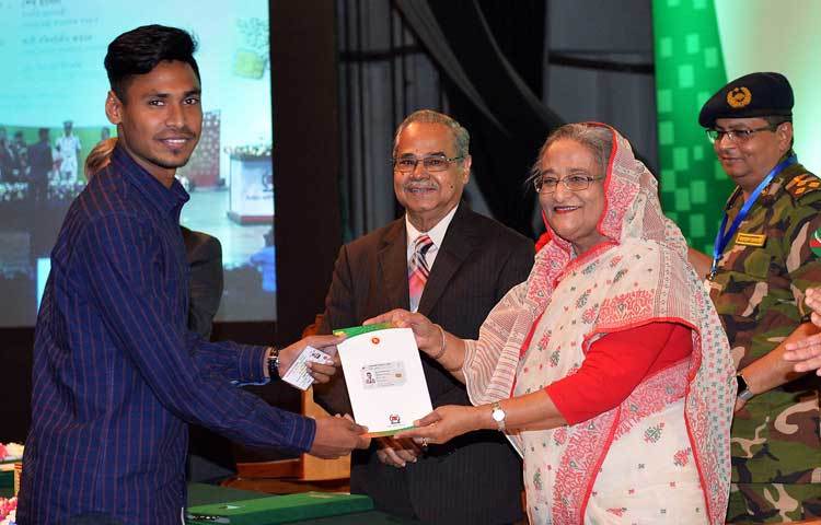প্রধানমন্ত্রীর হাত থেকে স্মার্টকার্ড গ্রহণ করছেন কাটার মাস্টারখ্যাত ক্রিকেটার মোস্তাফিজুর রহমান।