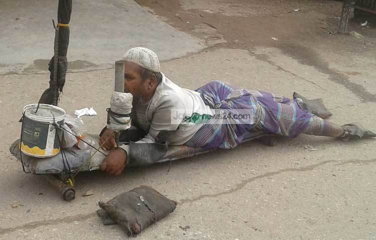 বেয়ারিংয়ে গাড়িতে এই ভিক্ষুক ভিক্ষা চাইছেন। ছবি : মনিরুজ্জামান উজ্জ্বল।
