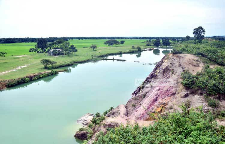 পাহাড়ের ওপর-নিচে তাকালে দেখতে পাওয়া যায় দারুণ এক প্রকৃতি। পাহাড়ের নিচে যেখান থেকে মাটি তোলা হয়েছে সেখানে পানি। ছবি : মাহবুব আলম।