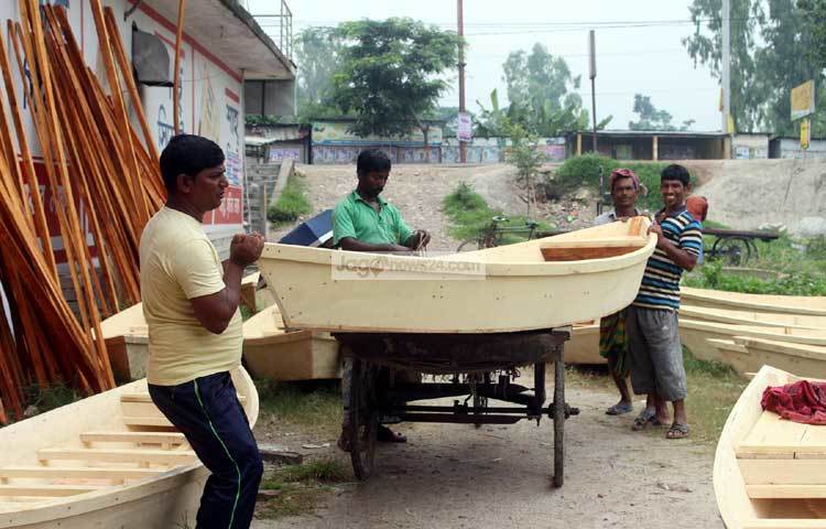 নৌকা কিনে ভ্যান গাড়িতে করে নিয়ে যাচ্ছেন এক ক্রেতা। ছবি : বিপ্লব দিক্ষিৎ।