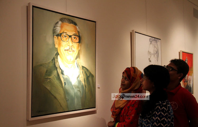 বঙ্গবন্ধুর ছবির সামনে দাঁড়িয়ে আছে প্রদর্শনীতে আসা দর্শনার্থীরা। সবাই বিমুগ্ধ নয়নে তাকিয়ে রয়েছেন বঙ্গবন্ধুর ছবির দিকে। ছবি : মাহবুব আলম।