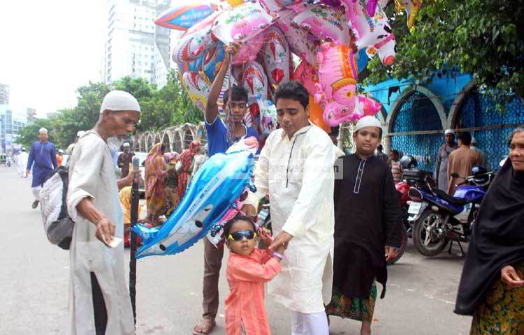 অভিবাকের সঙ্গে ঈদের নামাজ পড়তে আশা এই শিশুটি খেলনা কিনে দেওয়ার জন্য বায়না ধরেছে। ছবি : বিপ্লব দিক্ষিৎ।