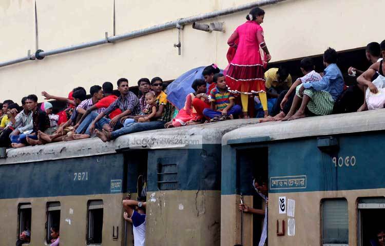 নারী, পুরুষ ও শিশুরা ট্রেনে আসন না পেয়ে ছাদে উঠেছে। কিন্তু তারপরেও সবার মনে ঈদের আনন্দের কোনো কমতি নেই। ছবি : বিপ্লব দিক্ষিৎ।
