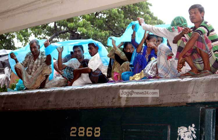 বৃষ্টি উপেক্ষা করে ট্রেনের ছাদে নাড়ীর টানে বাড়ি ফিরছে মানুষ। ছবি : বিপ্লব দিক্ষিৎ।