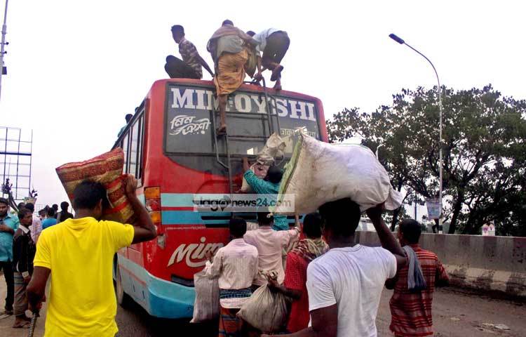 হাতের ভারি বোঝা নিয়ে বাসের ছাদে ওঠার প্রস্তুতি নিচ্ছেন ঈদে ঘরমুখো যাত্রীরা। ছবি : বিপ্লব দিক্ষিৎ।