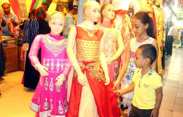 নিজেদের পোশাক বাছাইয়ে ব্যস্ত দুই শিশু। হাজারো রঙিন পোশাকের মাঝে খুঁজে পাচ্ছে না তাদের প্রিয় পোশাক। ছবি : বিপ্লব দিক্ষিৎ।