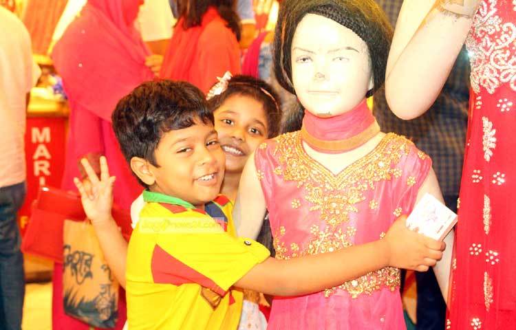 ঈদের পোশাক কিনতে এসে ম্যানিকিন নিয়ে ছবি তুলতে পেরে আনন্দে আত্মহারা দুই শিশু। ছবি : বিপ্লব দিক্ষিৎ।