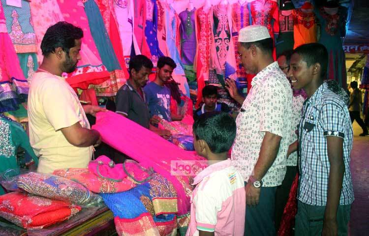 বাবার সঙ্গে ঈদের জামা কিনতে এসেছে দুই শিশু। তারা পরিবারের সবার জন্য কিনে নেবে ঈদের পোশাক। ছবি : বিপ্লব দিক্ষিৎ।