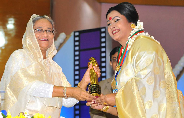 প্রধানমন্ত্রী শেখ হাসিনার কাছ থেকে পুরস্কার গ্রহণ করছেন খ্যাতিমান অভিনেত্রী চিত্রলেখা গুহ।