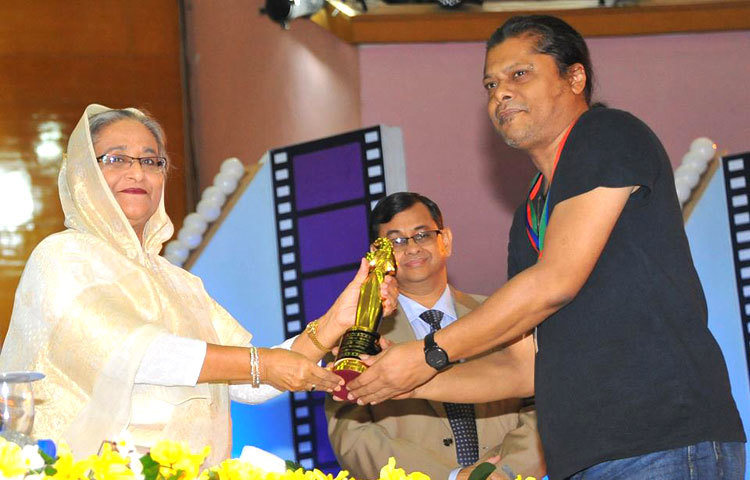 নগর বাউলখ্যাত ব্যান্ড তারকা জেমস প্রধানমন্ত্রী শেখ হাসিনার কাছ থেকে পুরস্কার গ্রহণ করছেন।