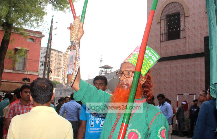 নিজামীর ফাঁসির দাবিতে অনড় এই মুক্তিযোদ্ধার এক হাতে জাতীয় পতাকা ও অন্য হাতে প্রতিকী ফাঁসির দড়ি। ছবি : বিপ্লব দিক্ষিৎ।