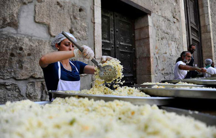 সিরিয়ার দামেস্কে শরণার্থীদের জন্য ইফতার বানাচ্ছেন এক নারী।