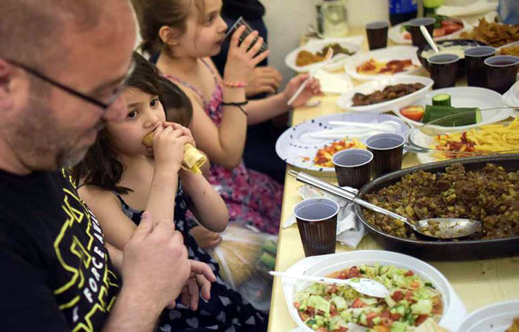 জার্মানির বার্লিনে শরণার্থীশিবিরে ইফতার করছে সিরিয়ার একটি পরিবার।