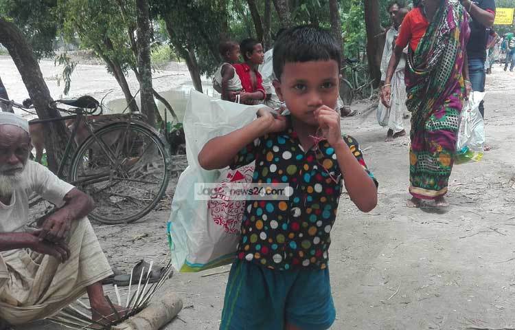 ত্রাণ সামগ্রী নিয়ে বাড়ি ফিরছে এক শিশু।