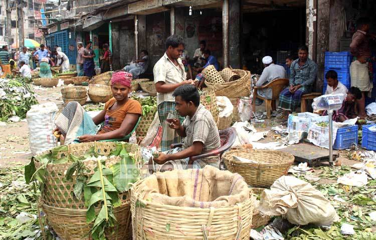 আম বিক্রির ফাঁকে চা বিস্কিট খাচ্ছেন এক বিক্রেতা। ছবি : বিপ্লব দিক্ষিৎ।