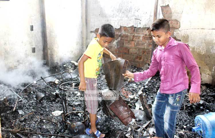অগ্নিকাণ্ডের এই দৃশ্য দেখে হতবাক দুই শিশু। ছবি : বিপ্লব দিক্ষিৎ।