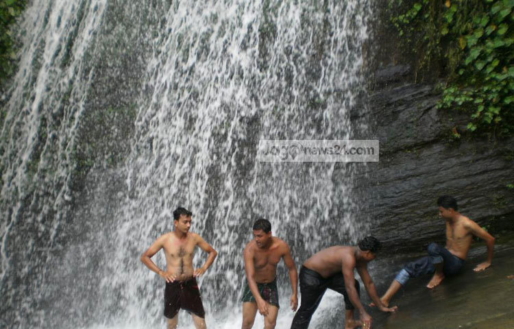 পাহাড়ি ঝর্ণায় গোসল করছেন একদল পর্যটক।