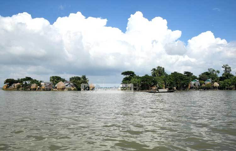 হাওরের থৈ থৈ পানির মাঝে ঘর-বাড়ি। মনে হচ্ছে ছোট দুইটি দ্বীপ। ছবি : মাহবুব আলম।
