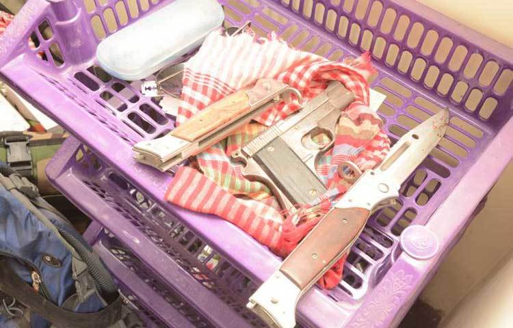 একটি প্লাস্টিকের ট্রেতে দুটি চাপাতি, একটি পিস্তল এবং একটি সানগ্লাস পাওয়া গেছে। 