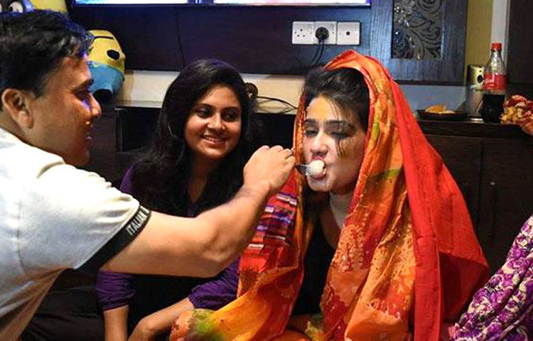 গায়ে গলুদ অনুষ্ঠানে মাহিকে মিষ্টি খাইয়ে দেওয়া হচ্ছে। ছবি : সংগৃহীত।