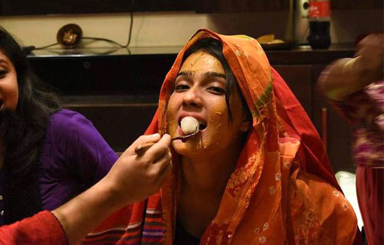 গায়ে হলুদ অনুষ্ঠানে মাহিকে মিষ্টি খাইয়ে দেওয়া হচ্ছে। ছবি : সংগৃহীত।