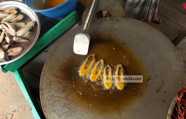 শুধু তেলে ইলিশ ভাজা হচ্ছে। ইলিশ ভাজার সুবাস মাওয়া ঘাটের চারদিকে ছড়িয়ে পড়ছে। ছবি : রবিউল ইসলাম পলাশ।