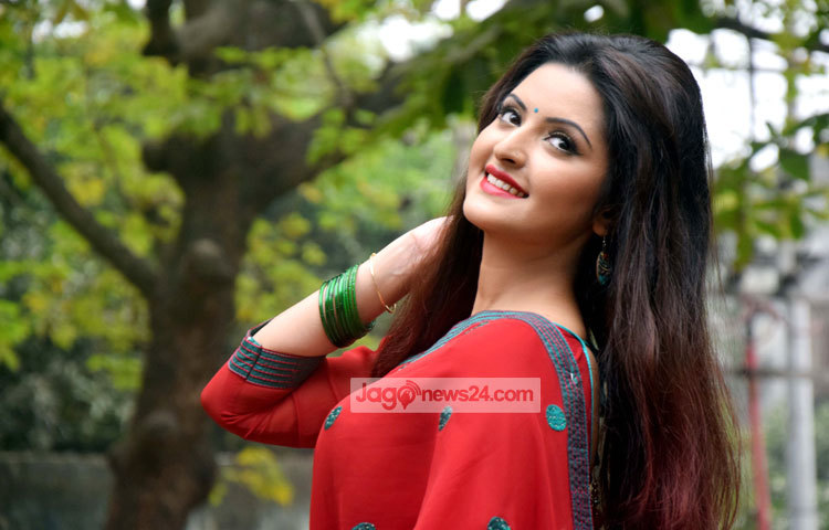 লাল পোশাকে সবুজের মাঝে এলোকেশী পরীমনি।হাসিতে যেন তার মুক্তো ঝরে। ছবি : মাহবুব আলম।