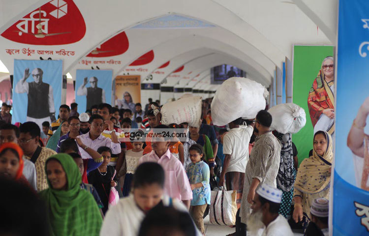 অনেক খাদ্য সামগ্রী ও প্রিয়জনদের দেওয়া নানা উপহার নিয়ে মানুষ ঢাকায় ফিরছেন। কারো হাতে ব্যাগ, কারো মাথায় বস্তা। ছবি : বিপ্লব দিক্ষিৎ।