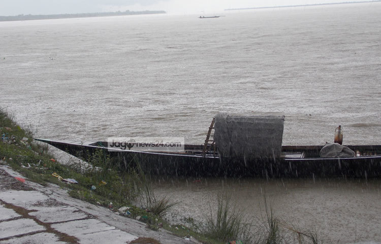 অঝোর শ্রাবণে ভিজছে পদ্মা ও তার উপর ভাসমান নৌকা, কিন্তু নৌকার মাঝির দেখা নেই। ছবি : রবিউল ইসলাম পলাশ।