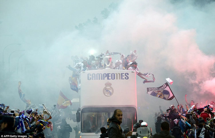 ছাদ খোলা বাসে করে প্লাজা ডি সিবেলেসে যাওয়ার পথে সমর্থকদের অভিবাদন গ্রহণ করছেন রিয়াল ফুটবলাররা।