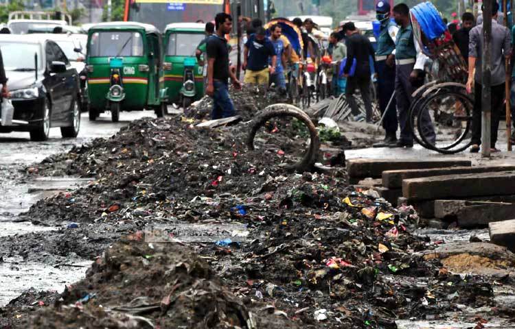 রাজধানীর কুড়িল বিশ্বরোড এলাকার ড্রেনের পয়োনিষ্কাশন ব্যবস্থার উন্নয়ন কাজ চলার কারণে রাস্তায় পথচারী ও যান চলাচলে বিঘ্ন ঘটছে। ছবি : বিপ্লব দিক্ষিৎ।