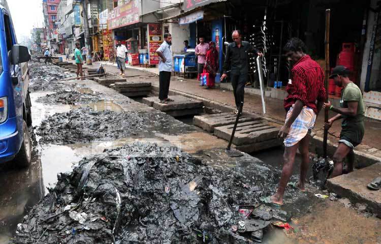 বৃষ্টির সময় এলেই প্রতিবছর ড্রেন পরিষ্কারের কাজ শুরু হয়। ফলে মানুষের ভোগান্তির মাত্রা বেড়ে যায়। ছবি : বিপ্লব দিক্ষিৎ।