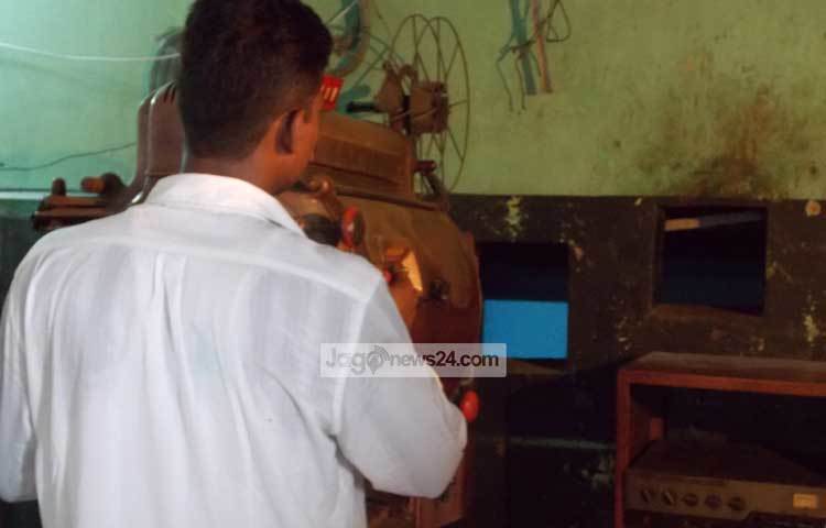 রাজবাড়ীর সাধনা সিনেমা হলের একজন প্রদর্শক এনালগ যুগের মেশিন দেখাচ্ছেন। এ হলের পূর্বের নাম ছিলো বনানী সিনেমা হল। ছবি : রবিউল ইসলাম পলাশ।